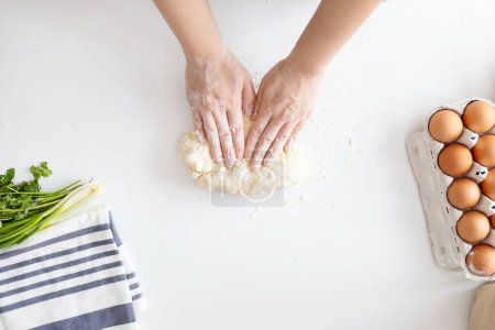 Photo for Woman kneading dough for Italian Grissini at white table in kitchen, top view. - Royalty Free Image
