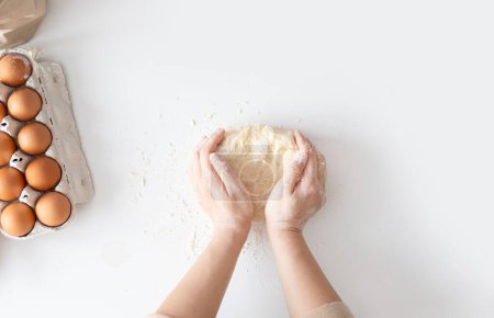 Photo for Woman kneading dough for Italian Grissini at white table in kitchen, top view. - Royalty Free Image