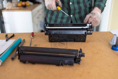 Ink replacements in printer cartridge. Printer service concept. Disassembly of the printer cartridge for its maintenance and refilling with toner. 