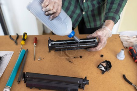 Ink replacements in printer cartridge. Printer service concept. Disassembly of the printer cartridge for its maintenance and refilling with toner. 