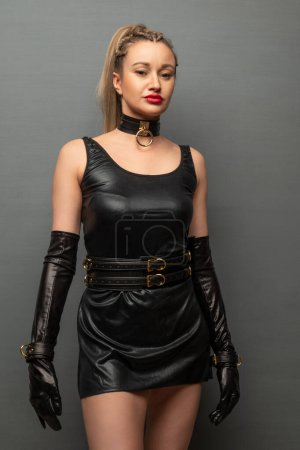Foto de Beautiful young woman in a leather dress and bondage set posing - Imagen libre de derechos