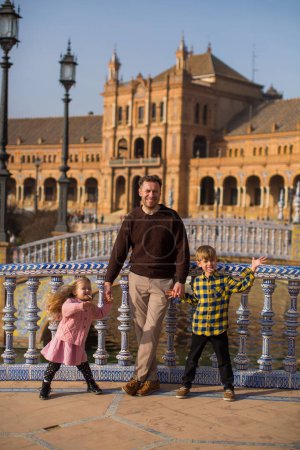 Photo for SEVILLE, SPAIN father and kids play outside Plaza Espana  in Sev - Royalty Free Image