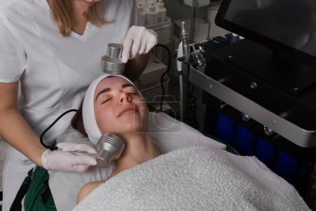 Photo for Led Light Therapy.Chromotherapy procedure with Hydrafacial device.Woman doing LED face therapy in blue. High quality photo - Royalty Free Image
