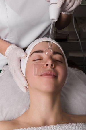 Veilchenstrahlbehandlung im Gesicht bei der Kosmetikerin. Ein Veilchenstrahl ist ein antikes medizinisches Gerät, das im frühen 20. Jahrhundert in der veralteten medizinischen Therapie namens Elektrotherapie verwendet wurde. Hohe Qualität