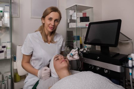 Photo for Tripolar rf face lifting. Hardware anti-aging procedure. Radio frequency lifting.Doctor looking to the camera. High quality photo - Royalty Free Image