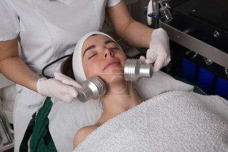 Photo for Led Light Therapy.Chromotherapy procedure with Hydrafacial device.Woman doing LED face therapy in blue. High quality photo - Royalty Free Image