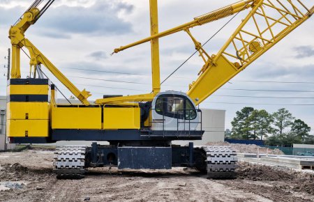 Photo for Crawler crane isolated front view on a construction site with focus on the machine deck, counterweight and treads. - Royalty Free Image