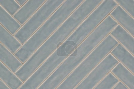 Long blue gray tile pattern with light glaze finish, diagonal pattern on a wall, background image. Color swatch design sample. 