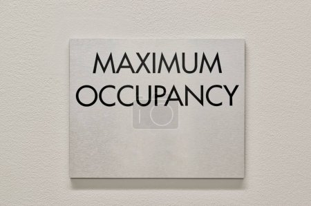 Maximum Occupancy sign on a white interior wall in a commercial building. An NFPA Fire Marshal requirement to safeguard buildings from overcrowding.