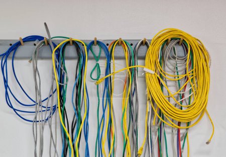 Foto de Coloridos cables eléctricos viejos que cuelgan de una pared. CAT5 Cables par trenzado para redes informáticas. - Imagen libre de derechos