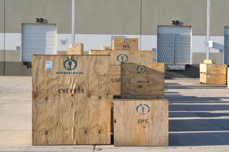 Foto de Houston, Texas, EE. UU. 12-08-2019: Cajas de madera para Kuehne y Nagel que contienen carga para varias compañías alineadas en un muelle de envío de almacén. - Imagen libre de derechos