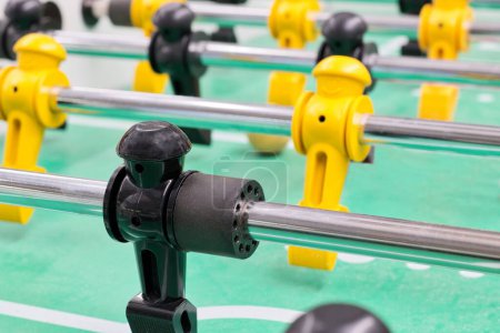 Photo for Foosball table game with plastic figures and metal rods low angle view, isolated selective focus. Popular tabletop soccer game played worldwide. - Royalty Free Image