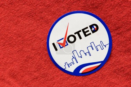 I Voted sticker on a red shirt indicating Republican party. Isolated directly above image, political concept.