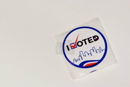 Unused I Voted sticker on a white table with copy space. Isolated directly above image, political concept.