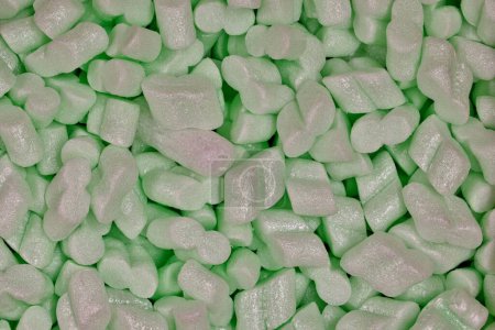 Green packing foam peanuts Styrofoam popcorn packaging noodles material closeup, Polystyrene cushioning protection shipping merchandise.