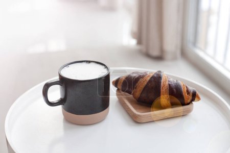 Foto de Café y croissant sobre mesa blanca. Desayuno francés. Copia espacio para tu texto - Imagen libre de derechos