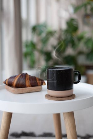 Foto de Café al vapor y croissant en la mesa blanca. Desayuno francés. Copia espacio para tu texto - Imagen libre de derechos