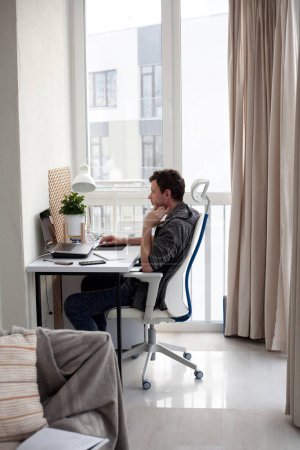 Foto de Joven estudiante masculino que trabaja en el ordenador en casa, oficina en casa, aprendizaje en línea - Imagen libre de derechos