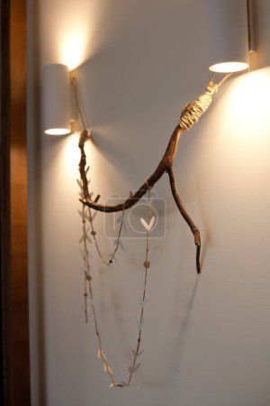 Foto de Rama de árboles en la pared con corazones decorativos, luces de pared, decoración rústica - Imagen libre de derechos