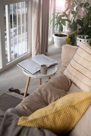 Foto de Un lugar acogedor para relajarse en un interior escandinavo con un sofá, mesa y revista - Imagen libre de derechos