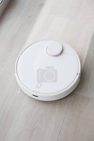 Foto de La aspiradora robot trapea el suelo dejando la limpieza detrás, casa inteligente - Imagen libre de derechos