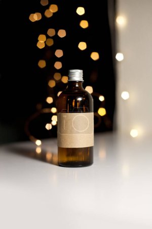 Foto de Una botella de vidrio ámbar oscuro cosmético con etiqueta de papel kraft, el minimalismo marca de embalaje se burlan de - Imagen libre de derechos