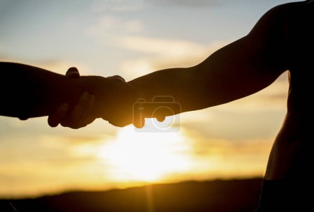 Téléchargez les photos : Silhouette à deux mains sur fond de ciel, connexion ou concept d'aide. Mains tendues, salut, silhouette d'aide, concept help. Un coup de main. Sauvetage, geste d'aide ou mains. - en image libre de droit