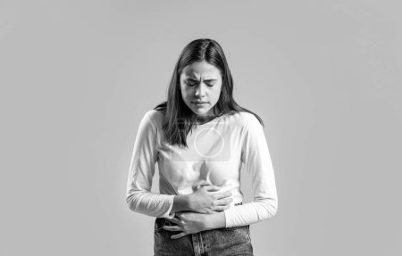 Photo for Stomach pain and others stomach disease concept. Girl having a stomachache. Young woman suffering from abdominal pain. Black and white. - Royalty Free Image