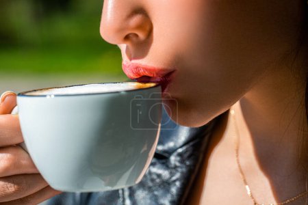 Foto de Primer plano de los labios de una chica tomando café. Taza blanca café caliente en las manos jovencita. Mujer disfrutando de café aroma en la cafetería. Chica bebiendo café. Mujer sosteniendo taza de café caliente en las manos. - Imagen libre de derechos