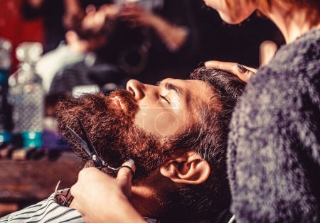 Man hairstylist. Beard man in barbershop. Hairstylist serving client at barber shop, bearded. Hairdresser, hair salon. Barber scissors, barber shop. Vintage barbershop, shaving.