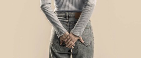 Foto de Mano de mujer sosteniendo su trasero porque tiene dolor abdominal y hemorroides. Mujer que sufre de hemorroides, dolor anal. - Imagen libre de derechos
