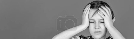 Photo for Despair, tragedy. Portrait of a sad boy holding his head with his hand. Little boy having a headache. Black and white. - Royalty Free Image