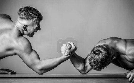 Arm wrestling. Two men arm wrestling. Hands or arms of man. Rivalry, closeup of male arm wrestling. Black and white.