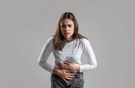 Woman with hand on stomach because nausea, painful disease feeling unwell. Ache concept. Stomach pain and others stomach disease concept. Woman suffering from abdominal pain. Woman stomach ache.