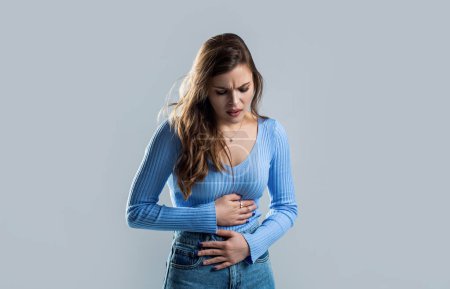 Woman with hand on stomach because nausea, painful disease feeling unwell. Ache concept. Stomach pain and others stomach disease concept. Woman suffering from abdominal pain. Woman stomach ache.