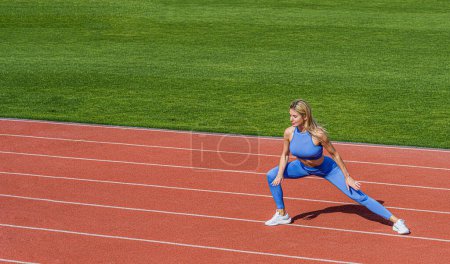 Sportlerinnen machen Sport. Trainer oder Trainer-Ausbildung. Läuferin dehnt sich vor dem Training. Sportliche Übungen und Stretching im Stadion. Körperliches Training Mädchen. Fittes Mädchen macht Ausfallschritt.