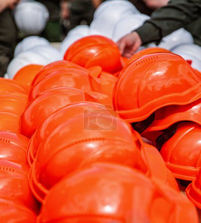 Helmgruppe für sicheres Arbeiten in Baubetrieben. Harter Hut Für sicheren Arbeitsplatz. Teamarbeit im Bauteam muss Qualität haben. Gelbe Schutzhelme. Orangefarbene Schutzhelme.