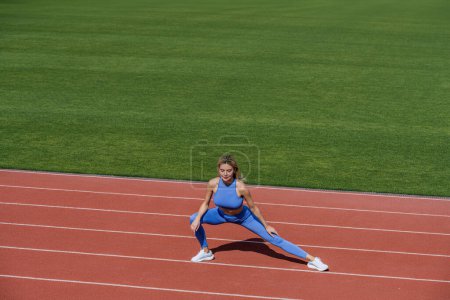 Female runner stretching before workout. Sports exercises and stretching in the stadium. Physical training girl. Fit girl do outward lunging. Physical training education. Sports lesson.