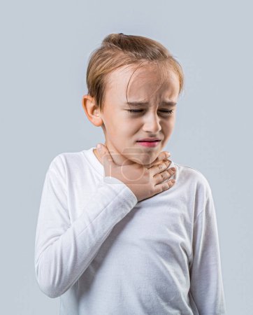 Little boy with sore throat touching her neck.Sore throat sick.Little man having pain in her throat. Ill little boy with sore throat. Ill child with sore throat. Sore throats in a child.