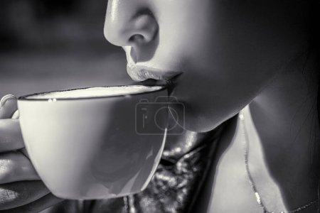 Girl drinking coffee. Woman holding cup hot coffees in hands. Black and white.