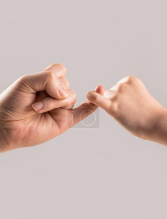 Dos manos enganchan los dedos meñiques para prometer, jurar o pedir reconciliarse. Niño enganche dedo meñique juntos. Dedo meñique de ambas manos.