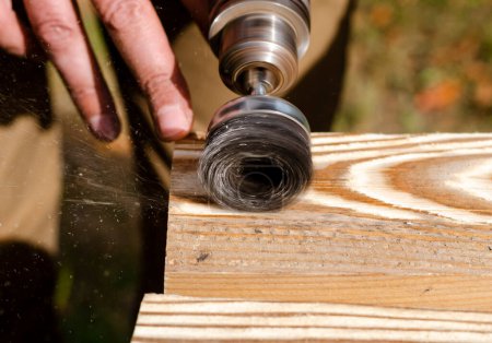 Téléchargez les photos : La transformation du bois. Mains d'un homme avec un outil électrique - en image libre de droit