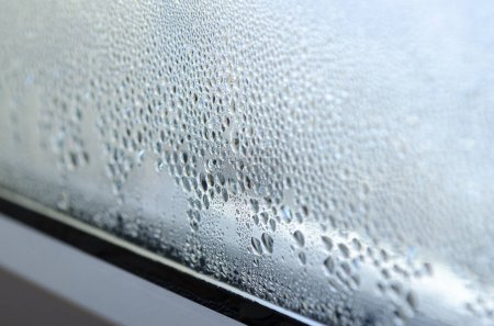 Effet de serre. Gouttes de condensation sur le verre d'une fenêtre métal-plastique.