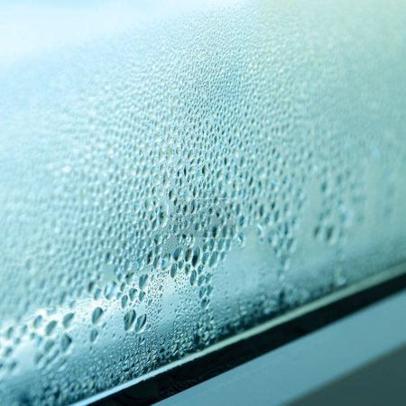 Téléchargez les photos : Effet de serre. Gouttes de condensation sur le verre d'une fenêtre métal-plastique. - en image libre de droit