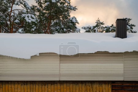 Dicke Schneeschicht hängt am Dachrand.