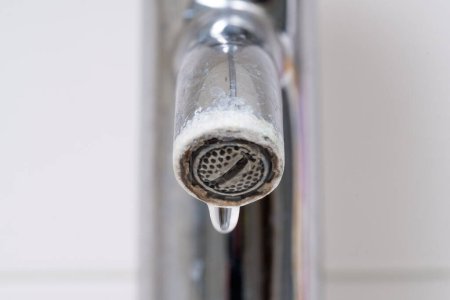 Une goutte d'eau qui fuit d'un robinet cassé. Fuite d'eau dans la salle de bain, corrosion close up.