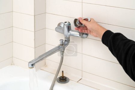 Photo for Leaking shower faucet. Broken bathtub handle. Emergency repair - Royalty Free Image