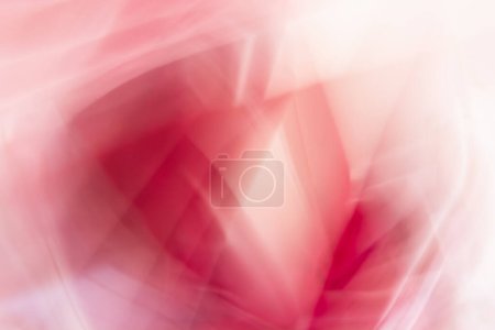 Une image abstraite montrant des nuances fluides de rouge, rose et blanc. Les lignes douces et floues créent un sentiment de mouvement et de fluidité.