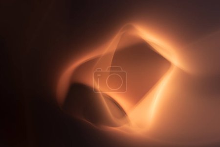 This image portrays an abstract pattern with warm tones of orange and brown, giving the impression of glowing shapes dancing in the darkness. The fluid forms create a sense of warmth and mystery.