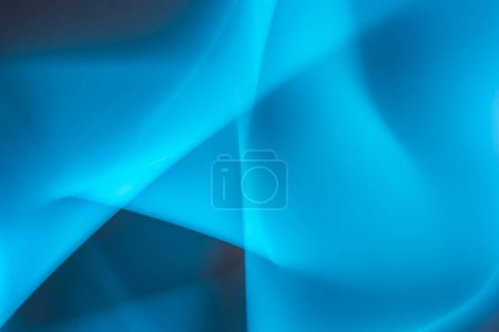Ein auffallend abstraktes Bild mit ineinander verschlungenen Schattierungen von leuchtendem Blau, das eine dynamische und fließende Form schafft. Die wechselnden Licht- und Schatteneffekte verleihen Tiefe und visuelles Interesse und rufen ein Gefühl von Fluidität und Bewegung hervor..